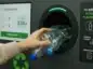 Dłoń wrzucająca plastikowe butelki do recyklomatu.