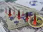 moneta XRP na tle banknotów i karty płatniczej, oraz strzałki sygnalizujące spadki