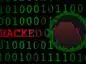 Zera i jedynki na zielono oraz napis HACKED, obok czerwony spadający wykres kursu tokena