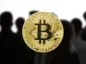 Bitcoin na tle tłumu anonimowych osób.