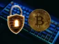 Bitcoin obok kłódki na tle klawiatury.