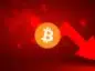 Logo Bitcoina w centrum na tle czerwonego tła i czerwonej strzałki sygnalizującej mocne spadki kursu