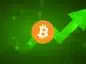 Logo Bitcoina w centrum, w tle zielona grafika ze strzałką sygnalizująca wzrosty