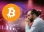 Zamyślony trader spogląda na Bitcoin.