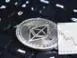 Moneta ETH położona na dużej czarnej klawiaturze od komputera i naniesiony wykres kursu Ethereum