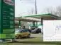 Widok na stację paliw benzynowych i naniesiony wykres ropy naftowej Brent