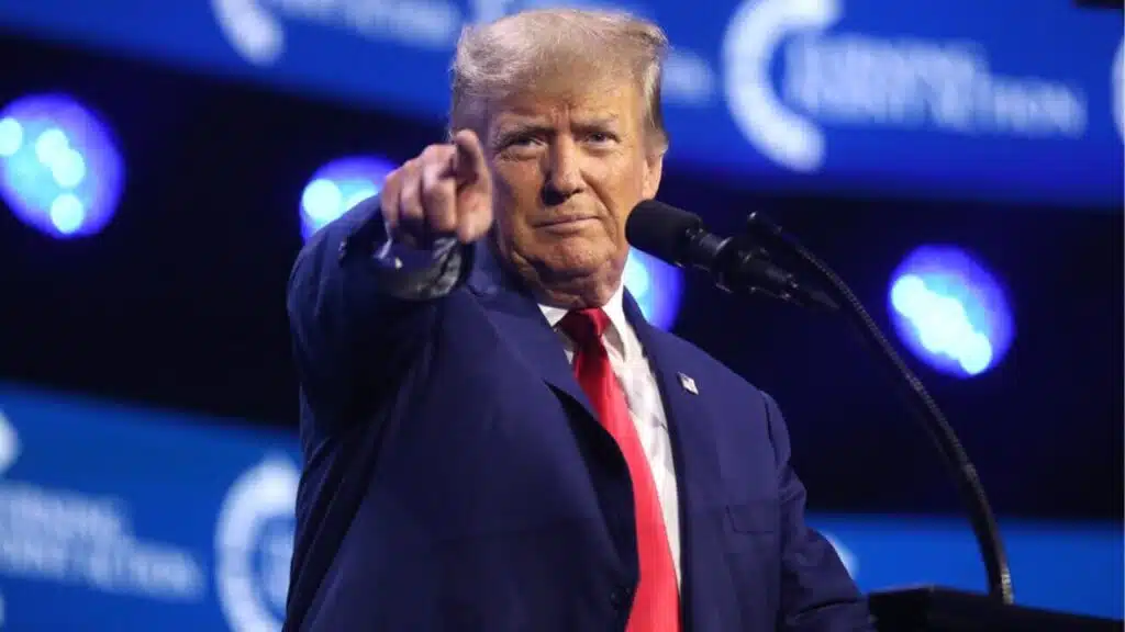 Donald Trump przemawia i wskazuje kierunek palcem