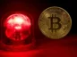 Bitcoin obok alarmu ostrzegawczego.