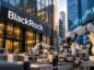 Roboty przemysłowe pracujące na linii produkcyjnej na tle biurowca z logo BlackRock. Ilustracja nowego funduszu ETF RBTX inwestującego w robotykę i technologie związane ze sztuczną inteligencją.