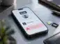 Smartfon z ekranem przelewu BLIK na numer telefonu i komunikatem ostrzegawczym, obok karta SIM i tacka SIM