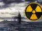 Atomowy okręt podwodny wynurzony na powierzchnię, na nim stoją marynarze W prawym górnym rogu symbol atomówki.