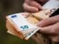 Trzymany w dłoni plik banknotów euro