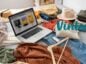 Ciuchy z Vinted i laptop rozrzucone swobodnie na łóżku